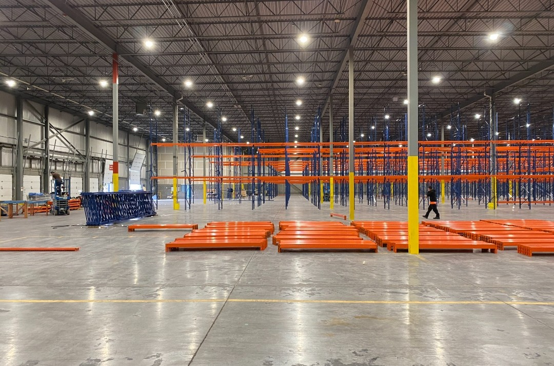 Warehouse filled with newly installed orange and blue pallet racking